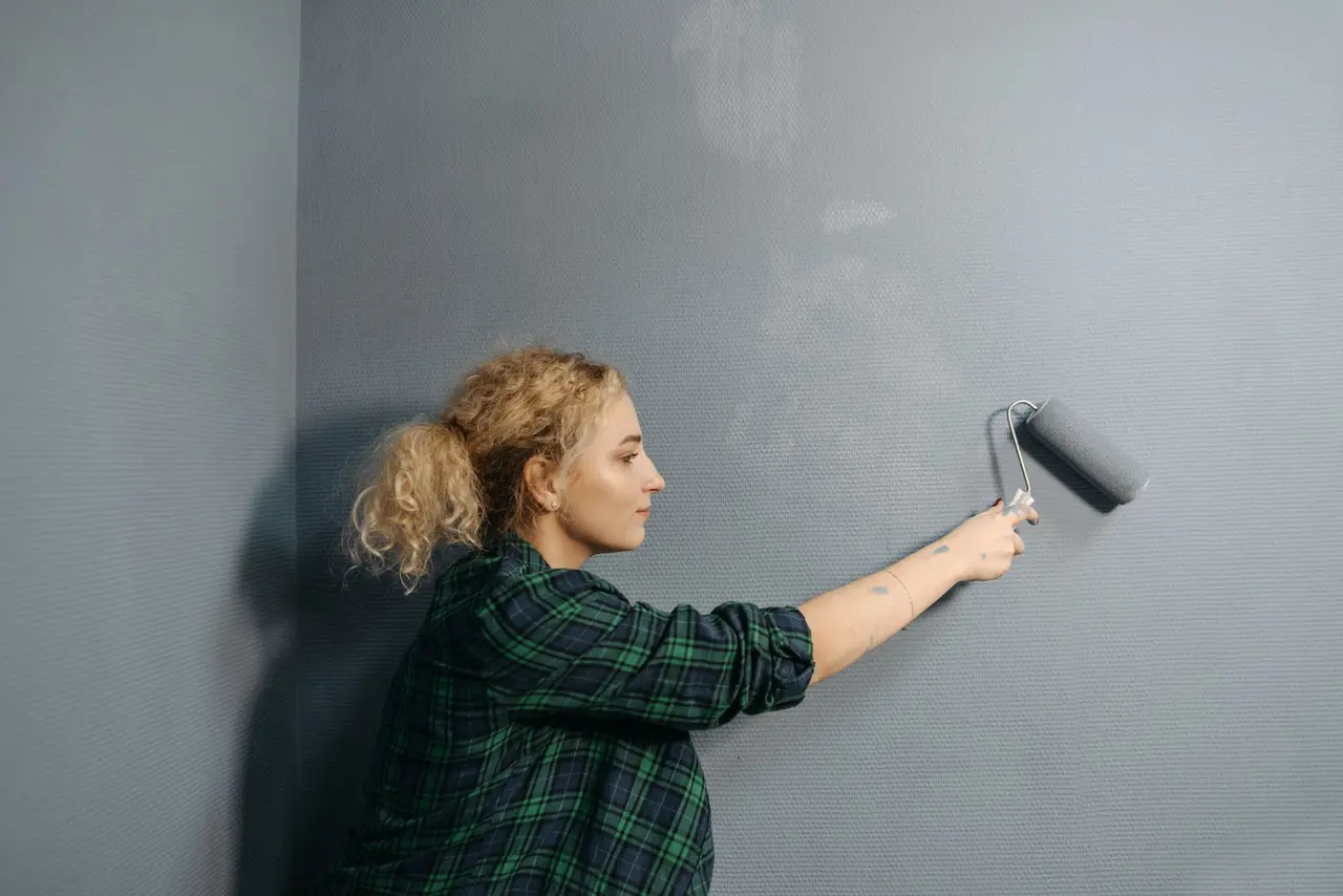 A professional painter cutting in a wall edge with a brush in a freshly painted room